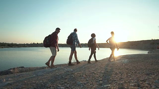 阳光下的背包客漫步在海岸上视频素材