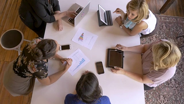 不同的商界女性在会议期间使用笔记本电脑、手机和平板电脑视频素材