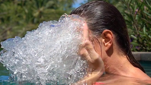 慢镜头:女孩在丛林中的游泳池里用水泼脸视频下载