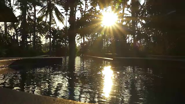 特写:阳光反射在豪华度假村的游泳池水面在日落视频下载