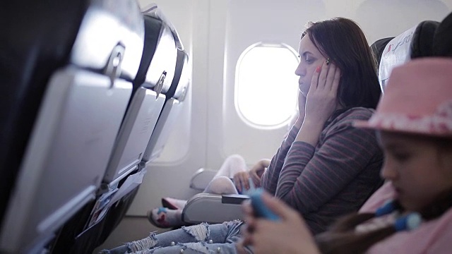 飞机上有个女人吐在纸袋里。坐飞机的旅客会感到恶心。飞机上恶心的乘客。飞机有乱流。视频下载