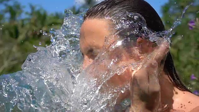 慢镜头:一名年轻女子在洗脸时，用spa水泼她的皮肤视频下载