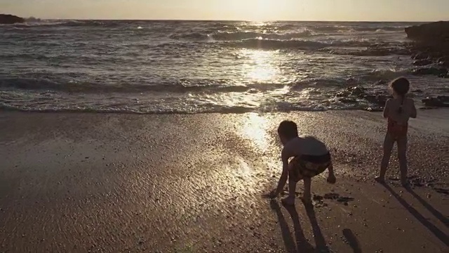 三个孩子一起在沙滩上玩视频素材