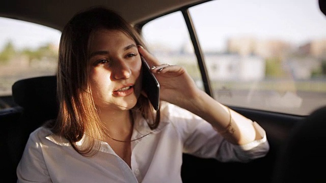 女商人乘出租车在城市里打电话视频下载