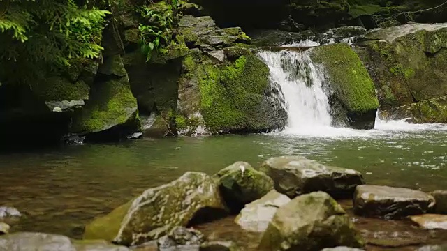 有小瀑布的山河或小溪。前景中的石头视频素材