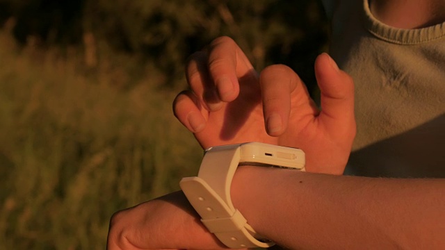 日落时分，一名女子在森林里使用智能手表视频素材