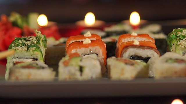 以蜡烛为背景的寿司特写。视频素材