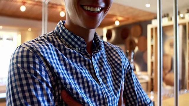 一个面带微笑双臂交叉站在4k餐厅的柜台前视频下载