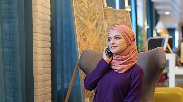 一个穆斯林女人微笑着打电话视频素材