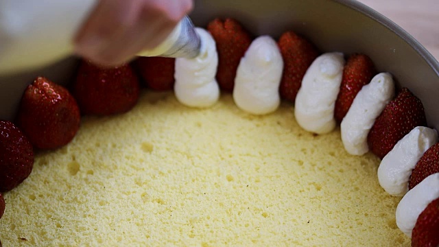 从糕点袋里挤出奶油。做草莓蛋糕视频素材
