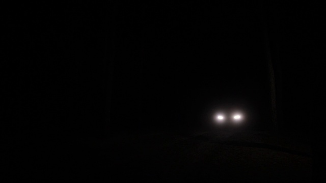 在黑暗的道路上，一辆汽车的前灯向我们驶来视频素材