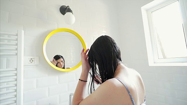 有魅力的女人在浴室梳头。视频下载