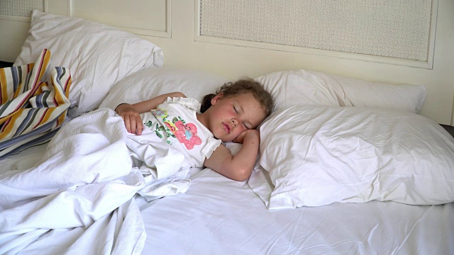 小女孩睡在白色的床上视频下载