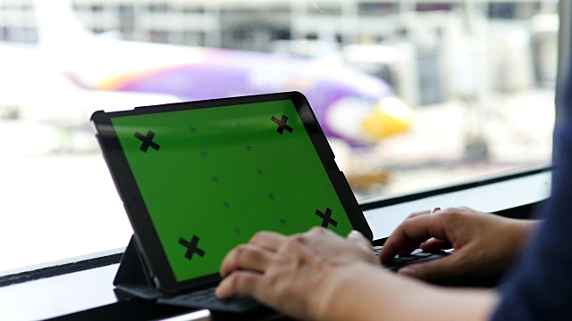 一名女子在机场使用平板绿色屏幕视频素材