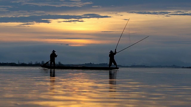 高清影像剪影两个身份不明的传统渔民准备在船上捕鱼视频下载