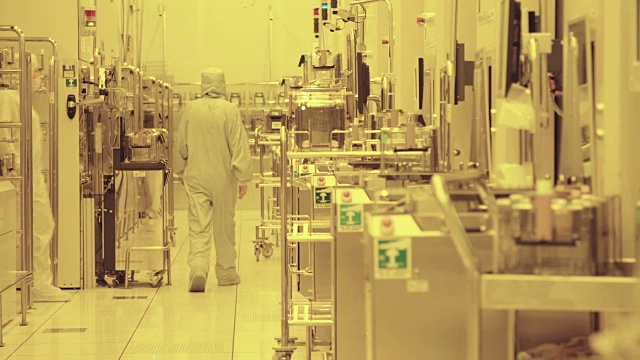 在半导体制造工厂，工人们穿着干净的西装视频素材