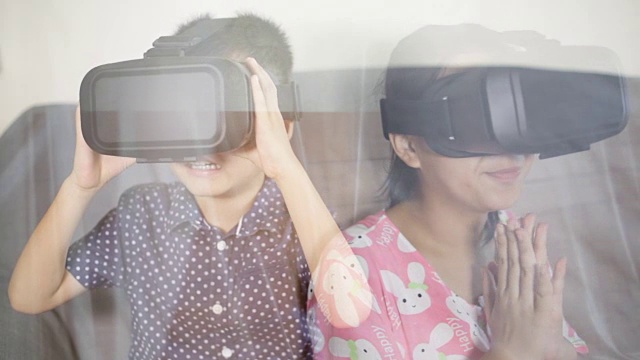 亚洲男孩和女孩在室内玩VR视频下载