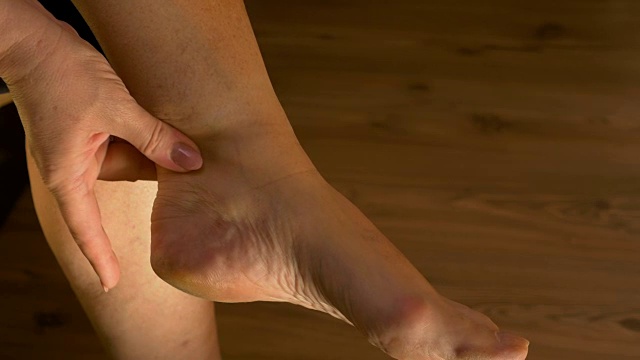 女人按摩脚踝和伸展的脚痛苦的特写视频素材