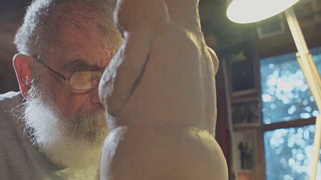 近距离的一个老雕塑家在他的小工作室泥塑视频下载