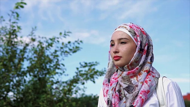 年轻的穆斯林妇女戴着明亮的头巾，户外肖像视频素材