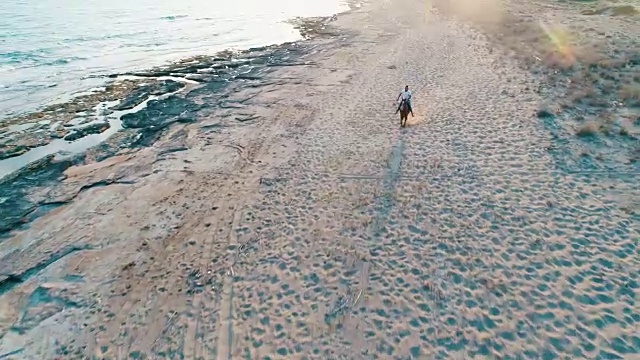 日落时分，海滩上骑马的男人视频素材