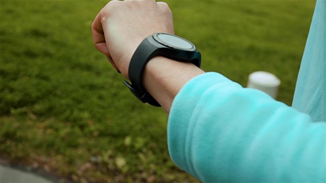 使用智能手表健身追踪器的女性跑步者视频素材