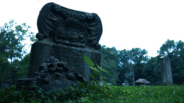 一个古老的哥特式石像鬼风格墓碑在恐怖的墓地万圣节附近视频素材
