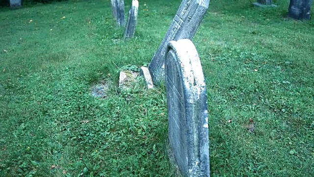 万圣节前夕，镜头移到令人毛骨悚然的墓地里残破的墓碑前视频素材