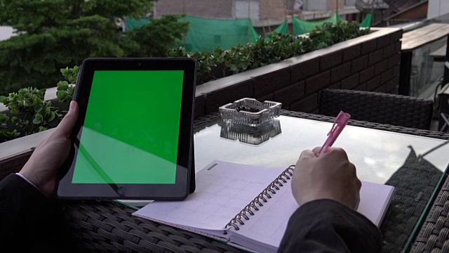 4k:商人在肩上用平板电脑绿屏写便条的特写视频素材