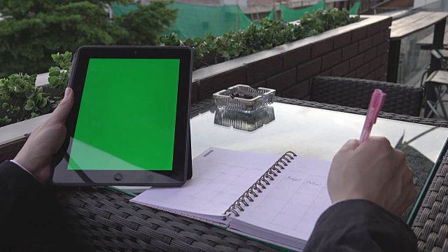 4k:商人在肩上用平板电脑绿屏写便条的特写视频素材