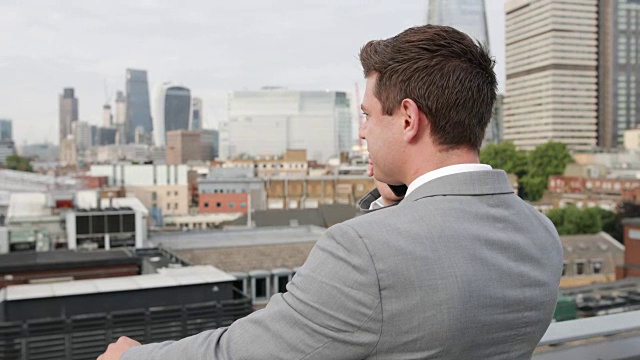 商人使用智能手机俯瞰伦敦城市天际线视频素材
