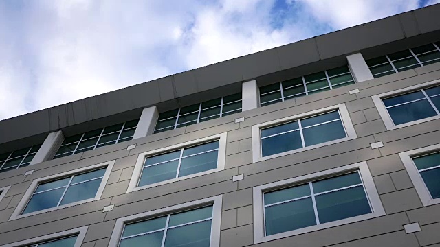 现代办公建筑多云的天空与反光玻璃立面的运动视频下载