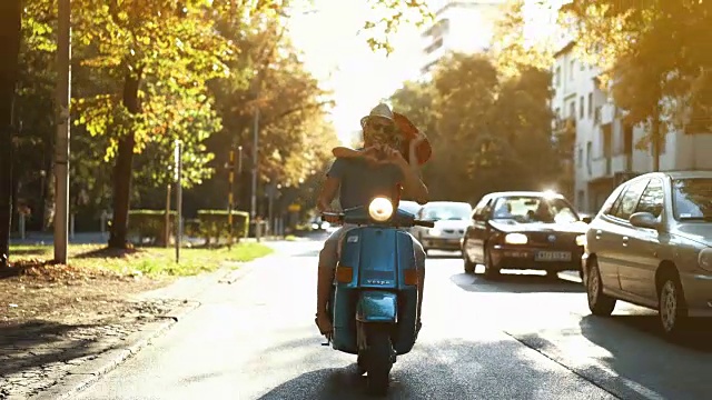 一对夫妇骑着摩托车穿过城市。视频素材