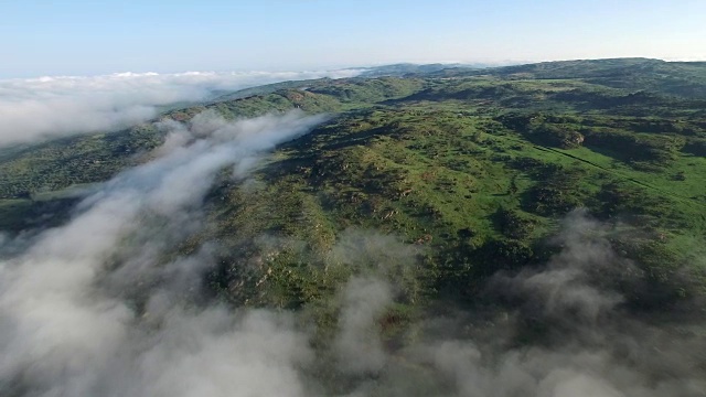 航拍在日出时飞过迷雾和雾蒙蒙的山脉视频下载