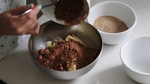 一名妇女正在向碗中添加烹饪自制巧克力的原料视频素材
