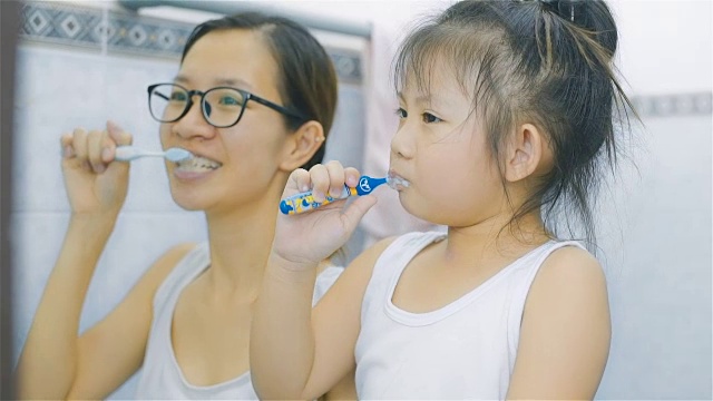 亚裔母亲和女儿一起在浴室刷牙视频素材