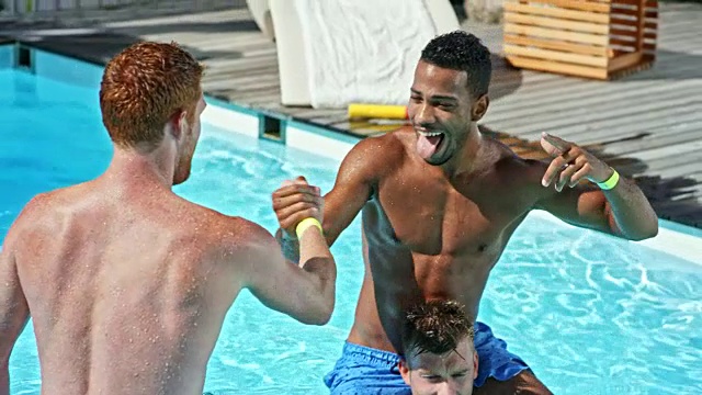 SLO MO两个年轻人在泳池派对上与朋友们进行肩战视频素材
