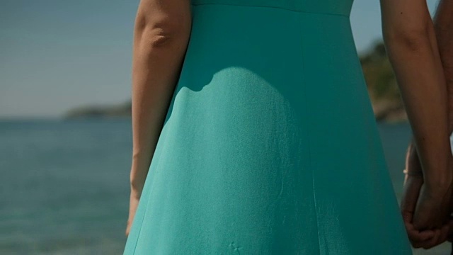 在海边有一个穿蓝绿色长裙的女人视频素材