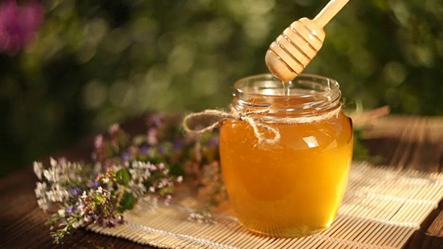 美味可口的蜂蜜在罐子在桌子上视频购买