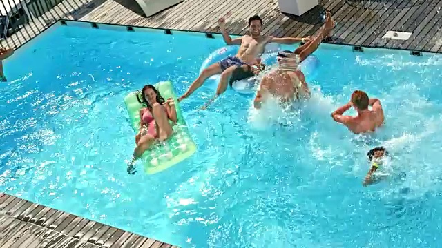 在一个炎热的日子里，三个男性朋友一起跳进游泳池视频素材