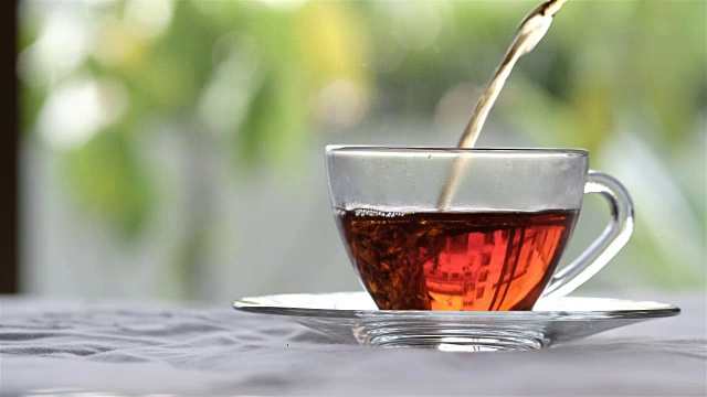 倒茶-热茶从一个茶壶流到另一个茶杯视频下载