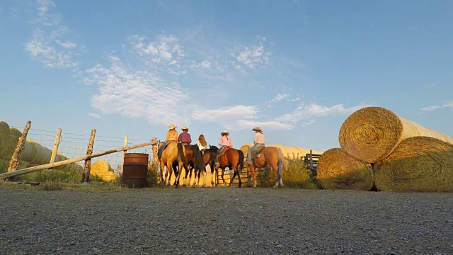 一群年轻的牛仔和女牛仔骑着马视频素材