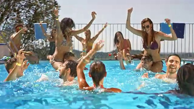 在一个热天的游泳池聚会上，人们在水里跳舞和大笑视频素材