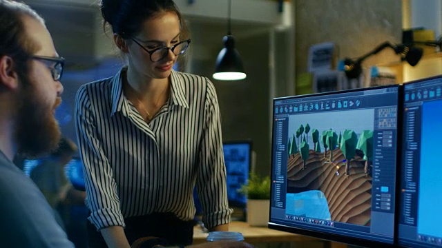 男性游戏开发者与女性关卡设计师对话两个显示器显示完全原创的游戏。他们在创意办公阁楼工作。视频素材