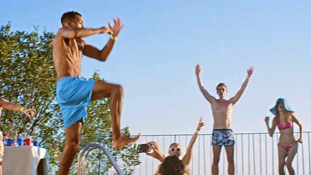 SLO MO DS多民族男子跳进游泳池，他的朋友为他欢呼视频素材