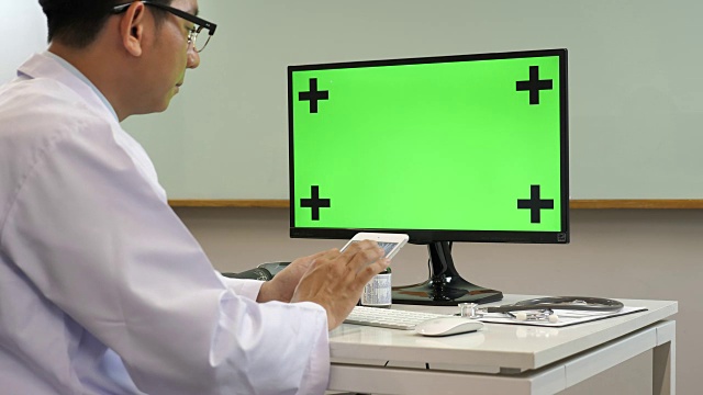 医生在医院使用绿色屏幕的电脑视频下载