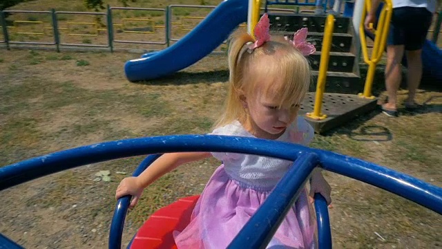 慢镜头:快乐的小女孩在公园里荡秋千。视频素材