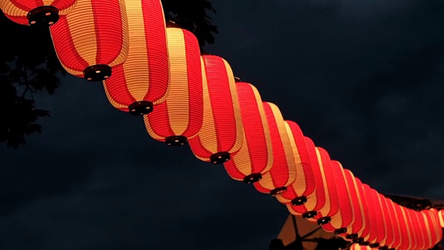 纸红白的日本灯笼在黑暗的天空中闪耀视频素材