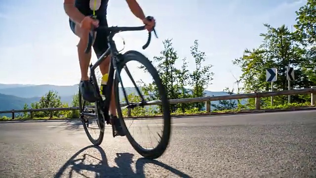 骑公路自行车的人在空旷的道路上骑行，背景是山脉视频素材