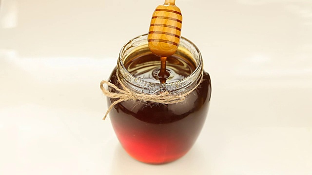 美味可口的蜂蜜在罐子在桌子上视频素材